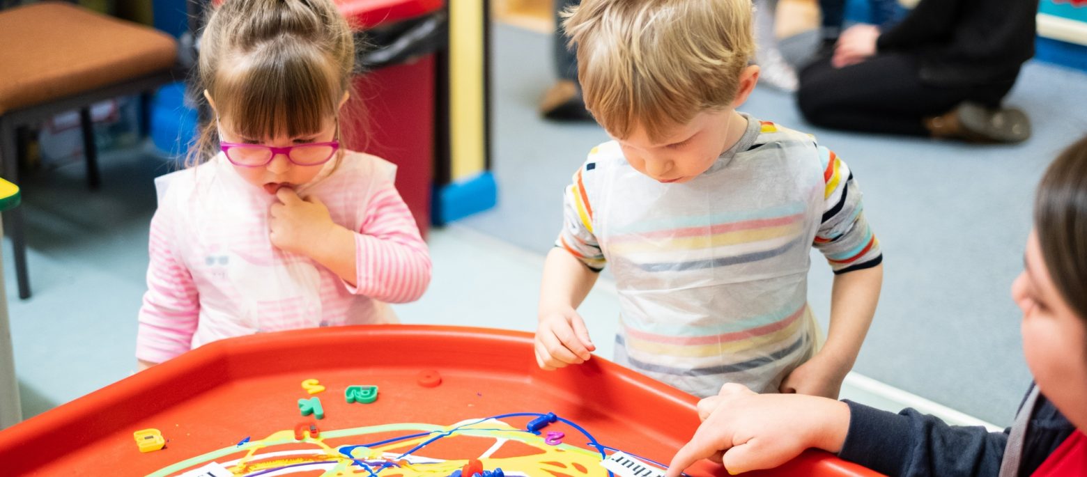 School children playing a game with plastic letters