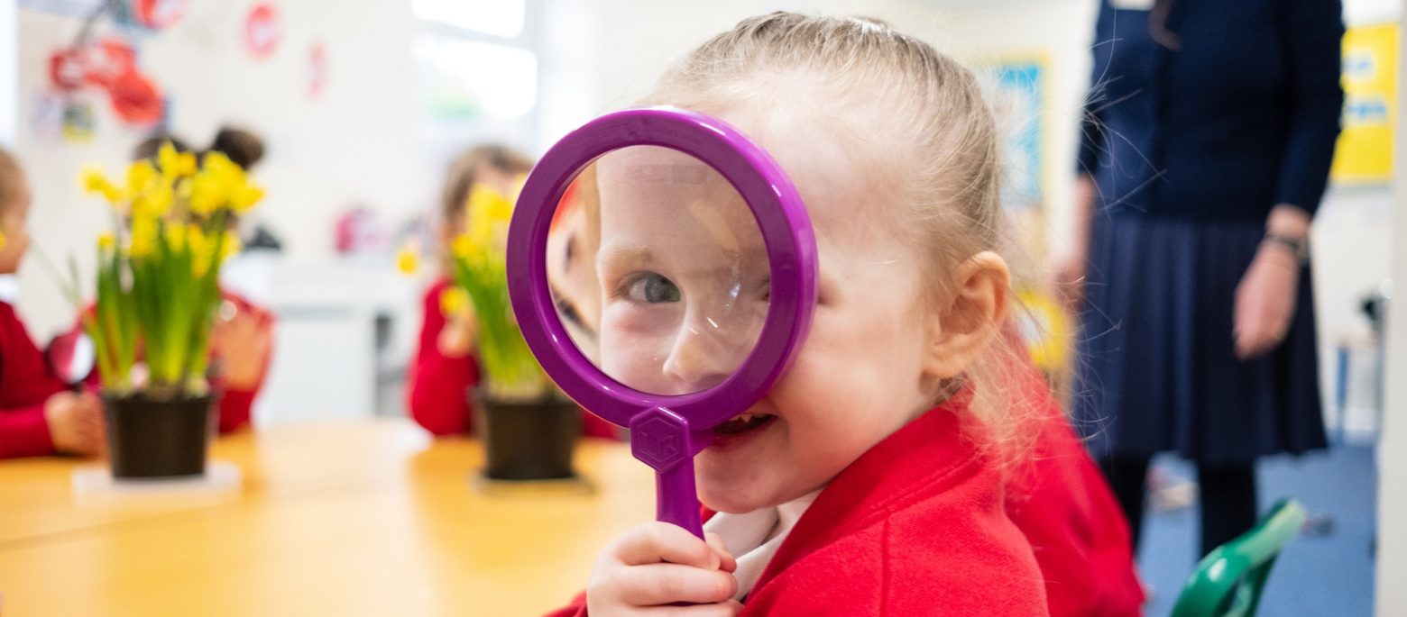 a girl using a magnifying glass