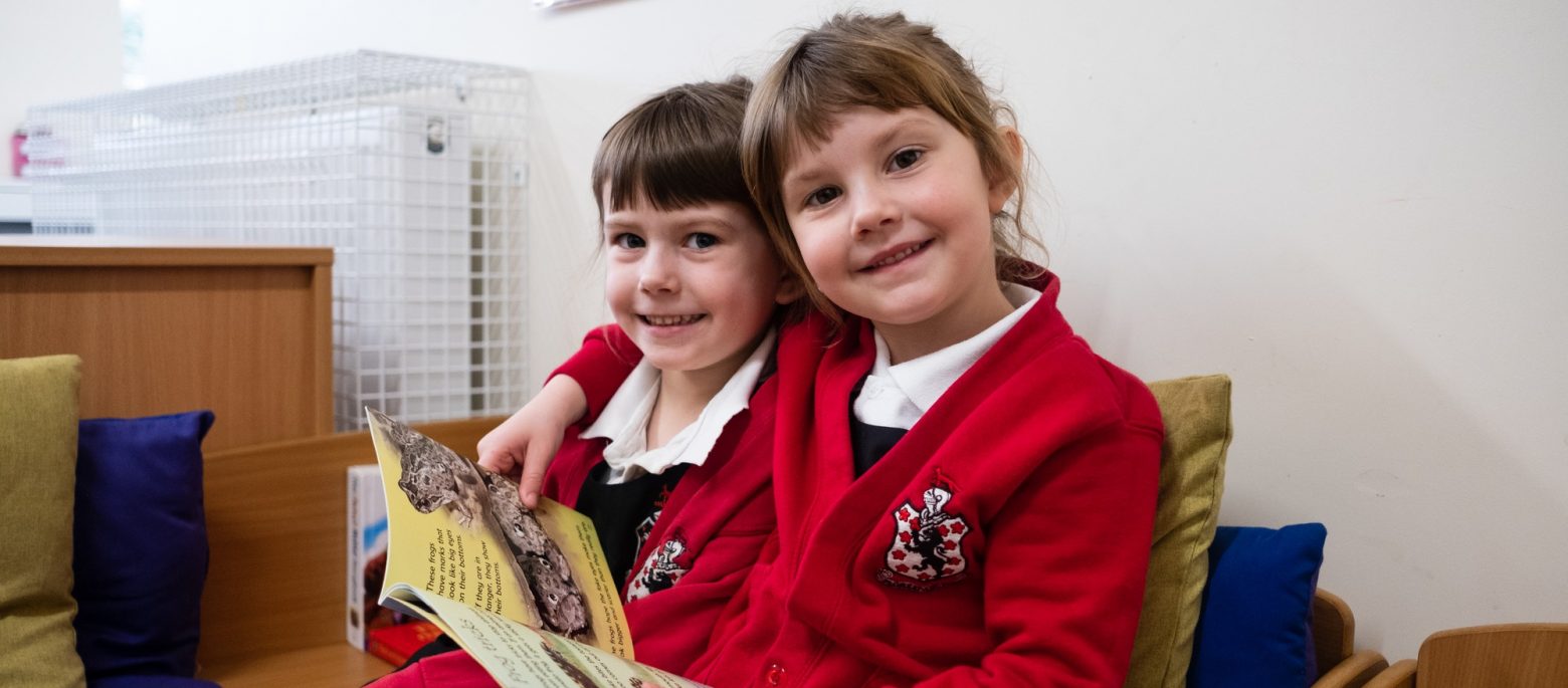 2 girls reading a book together