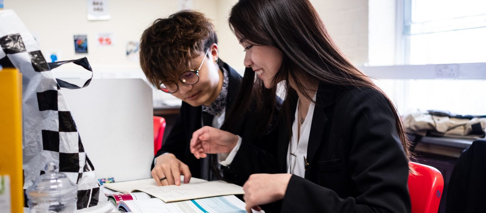 students from a sixth form in lucton reading a book