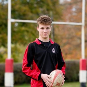 boy from a sixth form in lucton holding a rugby ball