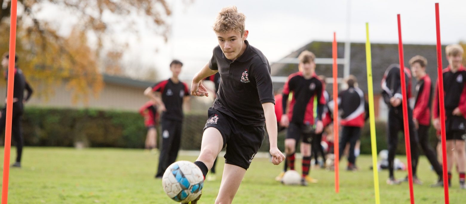 a boy trying to strike a goal