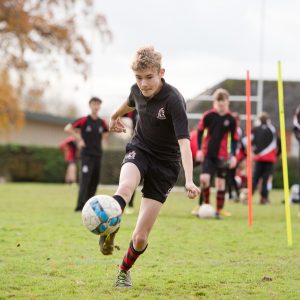 a boy trying to strike a goal