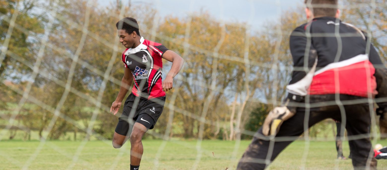 A boy is about to kick a football towards the goal