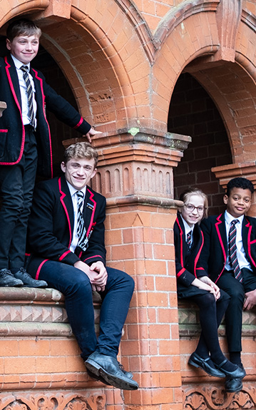 children sitting on a school wall