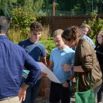 Students happily look at their GCSE results with their parents