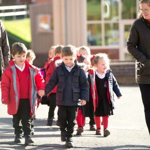 children holding hands and walking