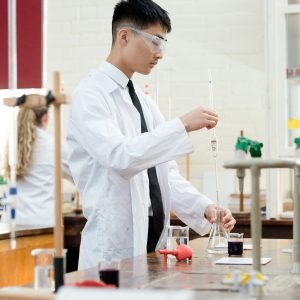 a student extracting liquid from a beaker