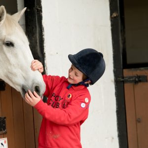 Kid stroking a horse
